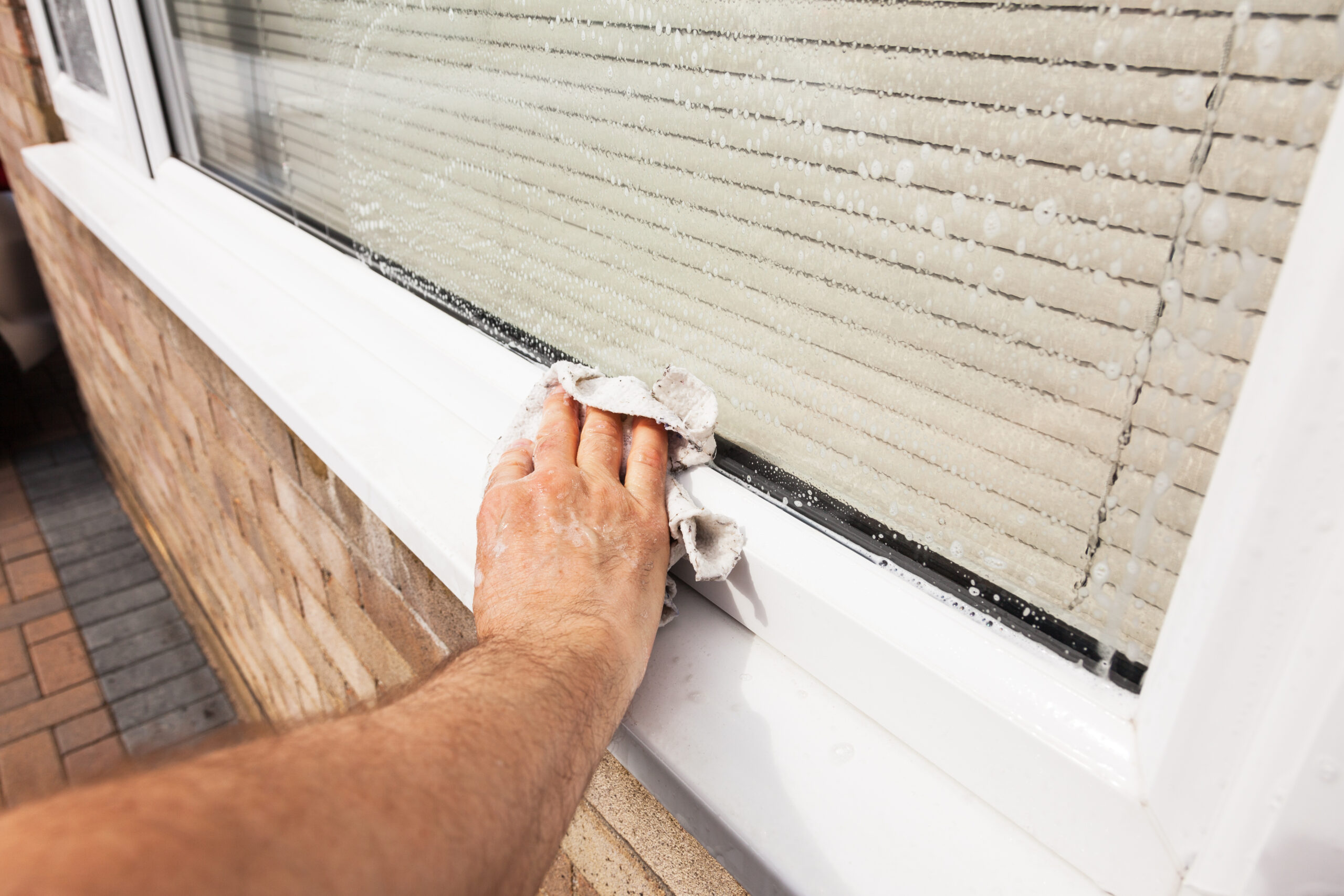 Man wiping down window
